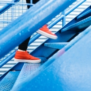 Orange Turnschuhe laufen eine Treppe empor